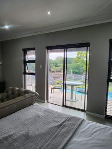 a bedroom with a bed and a view of a patio at Ntobongwana in Pinetown