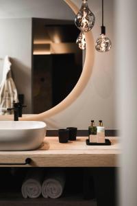 a bathroom with a sink and a mirror at Belia Lofts - ADULTS ONLY - Apartments in Appiano sulla Strada del Vino