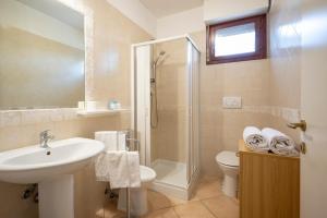 a bathroom with a sink and a toilet and a shower at Appartamenti La Vecchia Posta - 50 mt dal Mare in Marina di Grosseto +35 photos