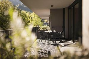 a patio with a table and chairs on a balcony at Belia Lofts - ADULTS ONLY - Apartments in Appiano sulla Strada del Vino