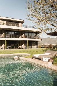 a house with a swimming pool in front of a building at Belia Lofts - ADULTS ONLY - Apartments in Appiano sulla Strada del Vino +108 photos