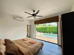 a bedroom with a bed and a ceiling fan at Maprao Villa in Mae Nam +15 photos