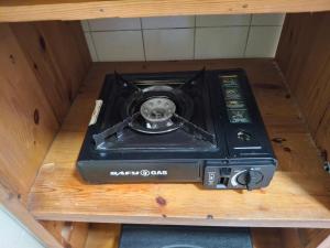 a stove sitting on top of a wooden shelf at Anne's Cottage in Durban