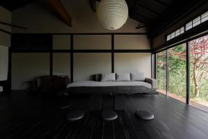 a bedroom with a bed in a room with windows at MUSUBI Hakone in Sengokuhara +85 photos