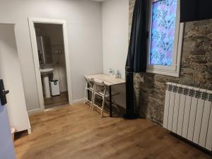 a room with a table and a stone wall at Pensión Casa Douro in Santiago de Compostela +39 photos