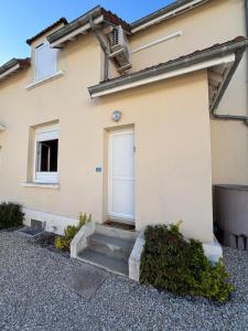 a house with a white door and a stairs at Résidences Les Murots 1 in Saint-André-les-Vergers