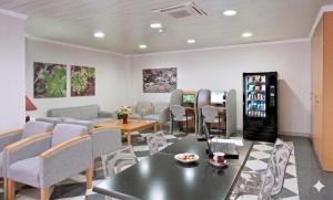 a waiting room with couches and a table and chairs at Hotel Verol in Las Palmas de Gran Canaria