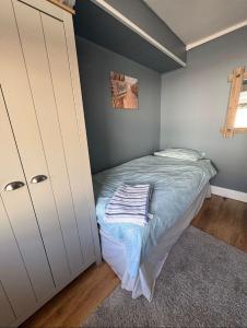 a small bedroom with a bed and a closet at 2 Bedroom - Seaside Apartment in Dawlish Warren