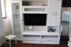 a white entertainment center with a flat screen tv at Tevere 20 House in Monza