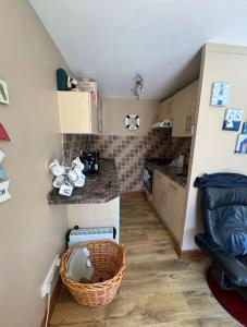 a small kitchen with a basket on the floor at 2 Bedroom - Seaside Apartment in Dawlish Warren