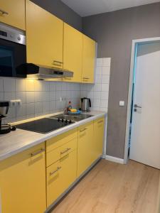 a kitchen with yellow cabinets and a counter top at Inselquartett - Fewo Hiddensee in Wiek auf Rügen +13 photos