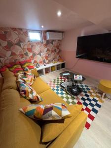 a living room with a couch and a flat screen tv at Résidences Les Murots 1 in Saint-André-les-Vergers