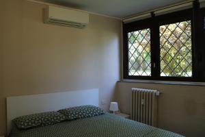 a bedroom with a bed and a window at Tevere 20 House in Monza
