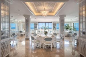 ein Esszimmer mit einem weißen Tisch und Stühlen in der Unterkunft Nixe Palace in Palma de Mallorca