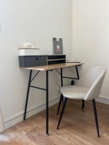 a desk with a printer and a white chair at Dodo Créole in Laval