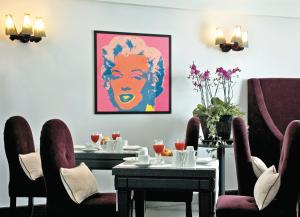a dining room with tables and chairs and a painting on the wall at Albergo Palazzo Decumani in Naples