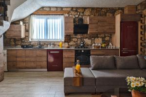 a living room with a couch and a kitchen at Kösedere Stone Houses in Karaburun