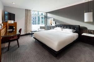 a bedroom with a large white bed and a desk at The Edwardian Manchester, A Radisson Collection Hotel in Manchester
