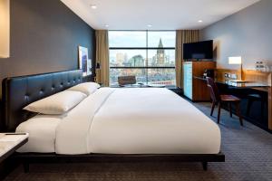 a large white bed in a hotel room with a desk at The Edwardian Manchester, A Radisson Collection Hotel in Manchester +41 photos