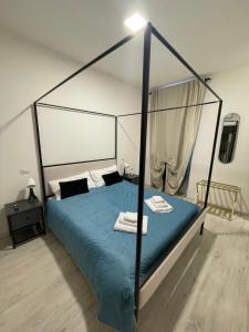 a bedroom with a canopy bed with blue sheets at l'impronta in Gorizia +7 photos