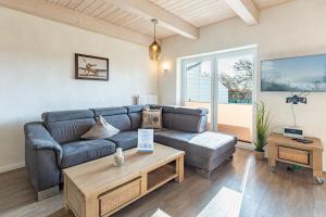 a living room with a couch and a coffee table at Ferienhaus Rotschenkel in Dagebüll