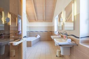 a bathroom with two sinks and a tub at Ferienhaus Kampfläufer in Dagebüll +25 photos