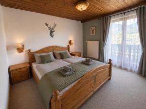 a bedroom with a large wooden bed and a window at Pension Sonneck in Pfarrwerfen