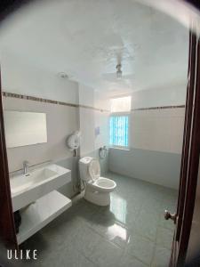 a white bathroom with a toilet and a sink at Hotel Nam Sơn in Hai Phong