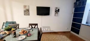 a dining room with a glass table and a television at Marina Nirvana vue sur l'eau in Le Grau-du-Roi