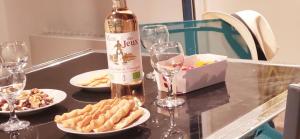 a bottle of wine and plates of food and wine glasses at Marina Nirvana vue sur l'eau in Le Grau-du-Roi