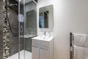 a bathroom with a white sink and a shower at The Dunes - Room 12 in Rhosneigr +15 photos