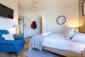 a bedroom with a bed and a blue chair at The Dunes - Room 12 in Rhosneigr