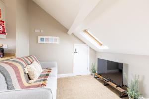 a living room with a couch and a tv at The Wave - Room 15 in Rhosneigr
