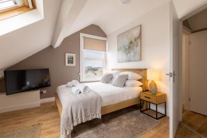 a bedroom with a bed and a tv at The Wave - Room 15 in Rhosneigr