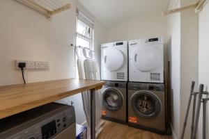 a laundry room with two washing machines and a counter at The Wave - Room 15 in Rhosneigr +18 photos