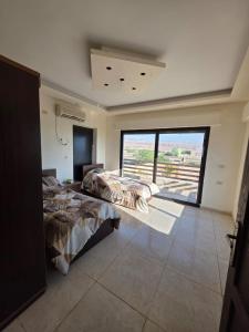 a bedroom with two beds and a large window at Green view in Al Mazār +10 photos