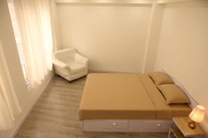 a small bedroom with a bed and a chair at BasantapurRooms in Kathmandu