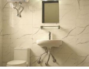 a bathroom with a sink and a toilet and a mirror at BasantapurRooms in Kathmandu +5 photos