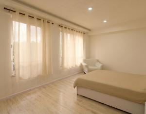 a bedroom with a bed and a chair and a window at BasantapurRooms in Kathmandu