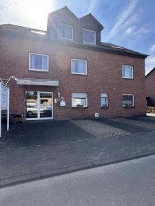 a red brick building with windows on a street at Frühstückspension Stenbrock in Grevenbroich