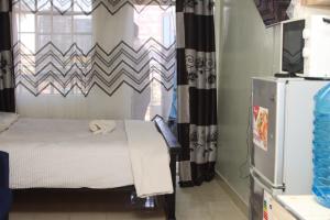 a small bedroom with a bed and a window at The Quiet Nest in Ruiru +1 photo