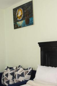 a bedroom with a bed and a picture on the wall at The Quiet Nest in Ruiru