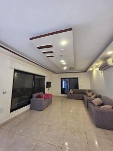 a large living room with couches and a tv at Green view in Al Mazār