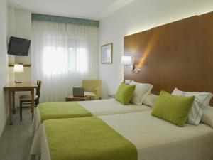 a hotel room with two beds and a television at Hotel Verol in Las Palmas de Gran Canaria