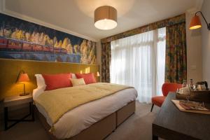 een slaapkamer met een groot bed en een raam bij Harper's Steakhouse with Rooms, Haslemere in Haslemere