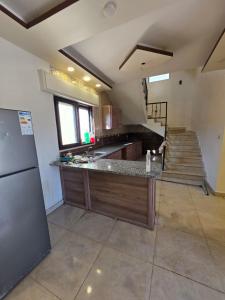 a large kitchen with a counter and a staircase at Green view in Al Mazār