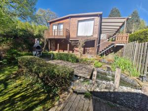 a house with a wooden walkway in front of it at Lilia Chalet in Durbuy