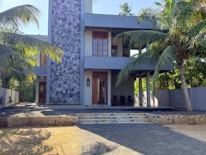 a building with palm trees in front of it at The Ceylon Slate in Tangalle