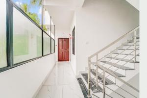 a hallway with stairs and a red door at Hotel O HMT Colony Kochi Formerly Pullans Arcade in Cochin
