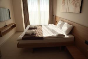 a bedroom with a bed with two towels on it at Hotel & Restaurant HAREA in Suharekë +45 photos